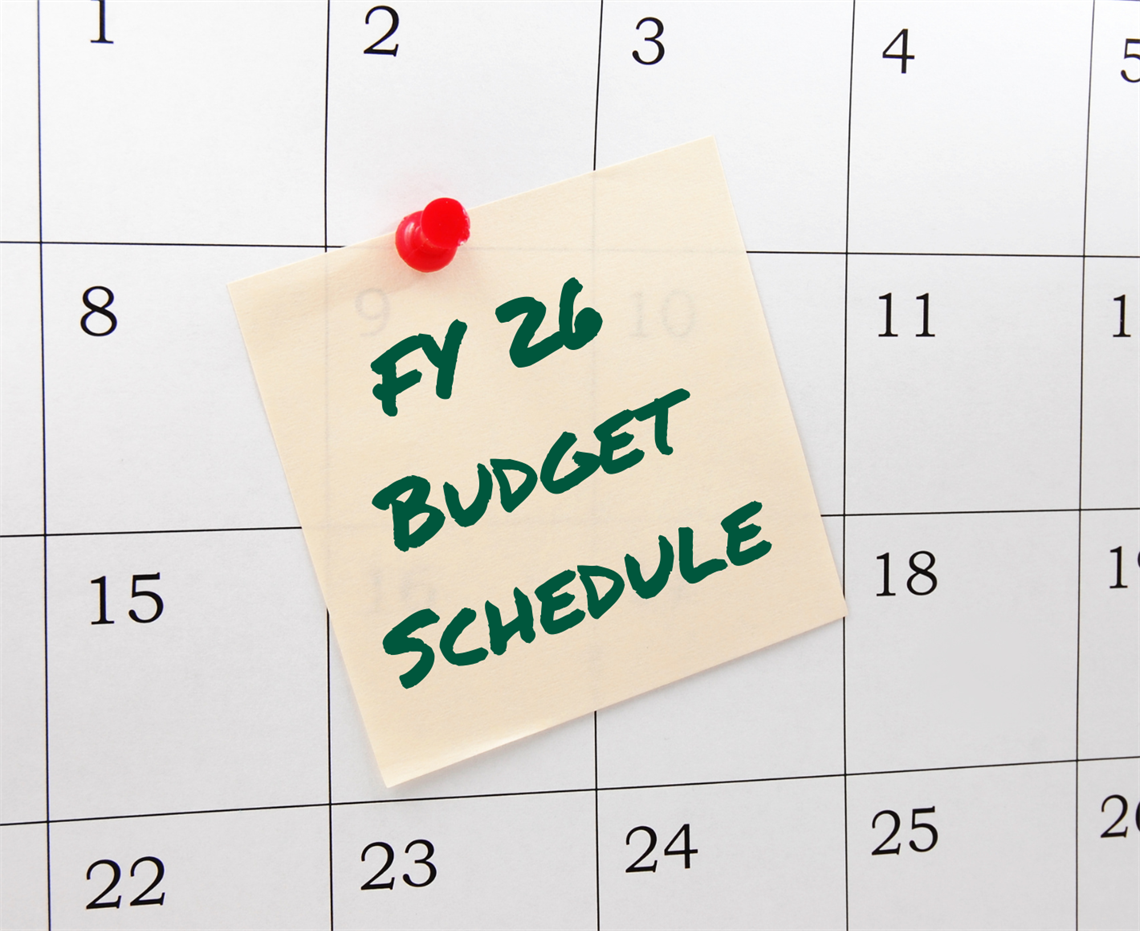 Calendar with post it note with FY26 Budget Schedule written on it